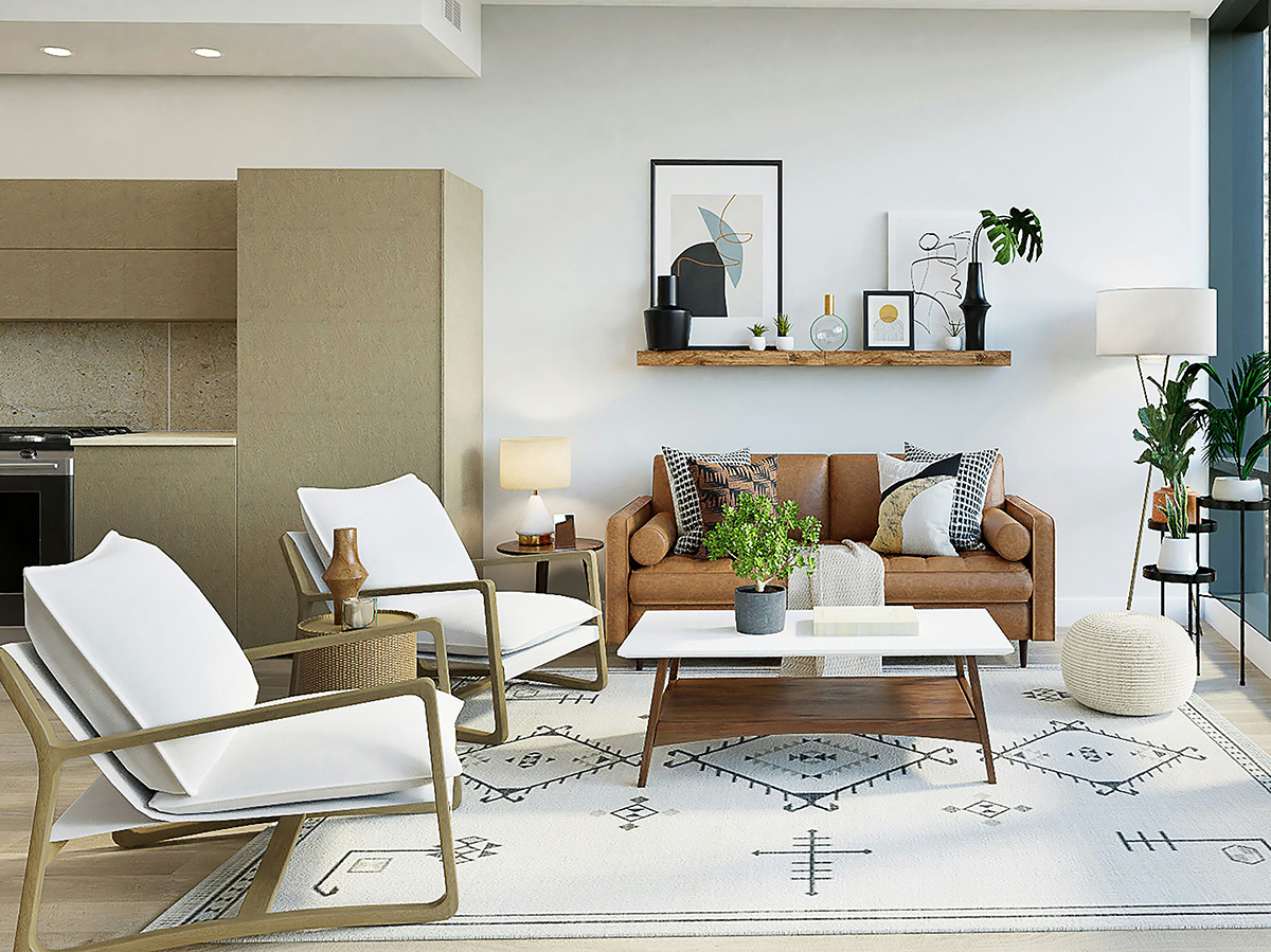 Ein modern und gemütlich eingerichtetes Wohnzimmer. Vorhanden sind u.a. ein braunes Ledersofa, gemütliche hellgraue Sessel, ein Regal mit Bildern sowie im Hintergrund eine beigefarbene Küchenzeile.